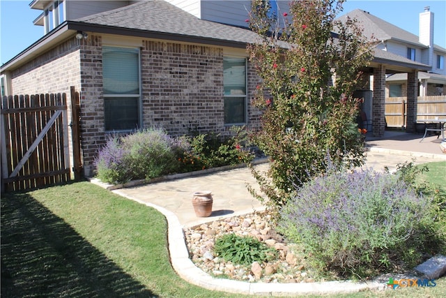 view of front facade featuring a front lawn and a patio area