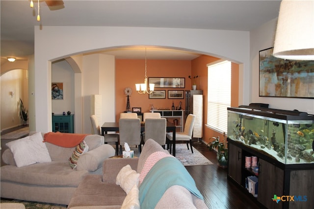 living room with dark wood-type flooring and ceiling fan with notable chandelier