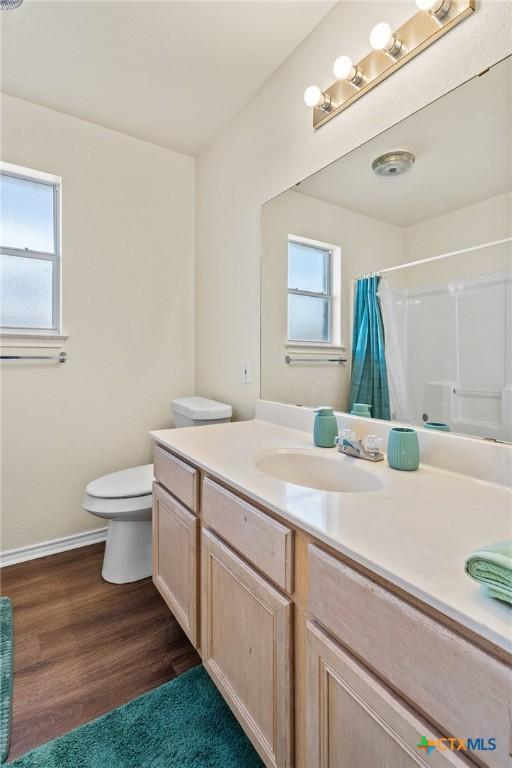 1801 Caprock Dr, Killeen, TX 76549 - full bath with vanity, plenty of natural light, curtained shower, and wood finished floors