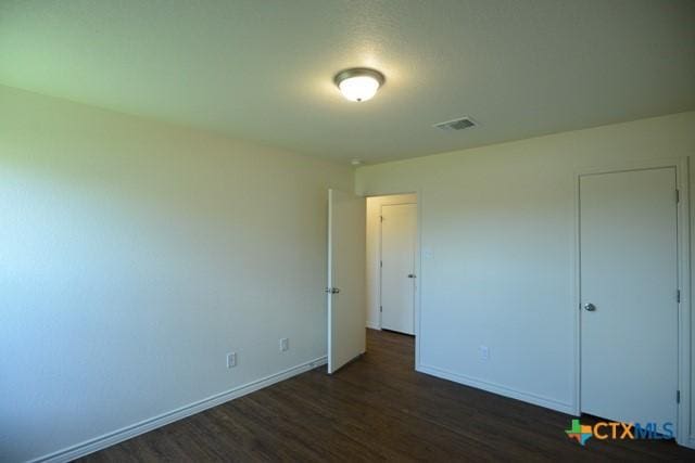 unfurnished bedroom featuring dark hardwood / wood-style flooring