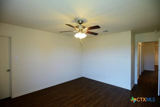 empty room with ceiling fan and dark hardwood / wood-style floors