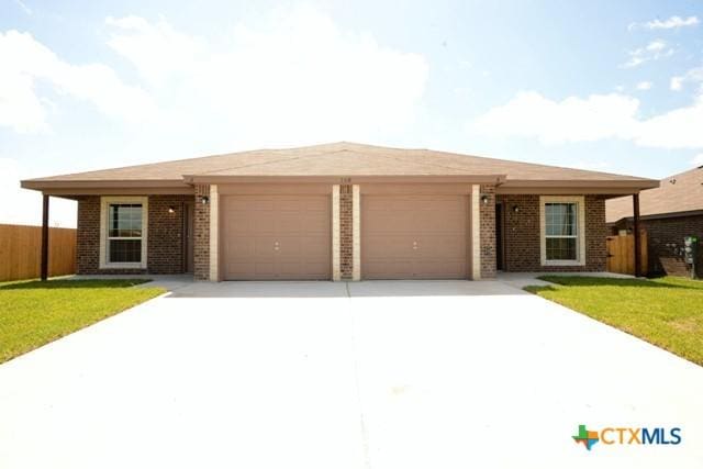 ranch-style home with a garage and a front yard