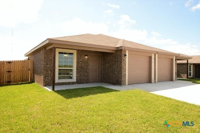 view of front of home with a front yard and a garage