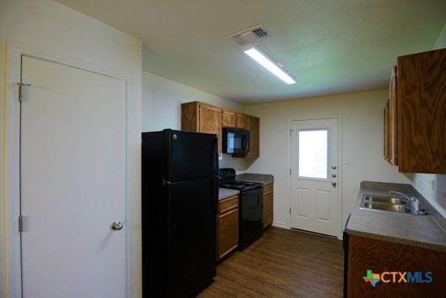 kitchen featuring dark hardwood / wood-style flooring, sink, and black appliances