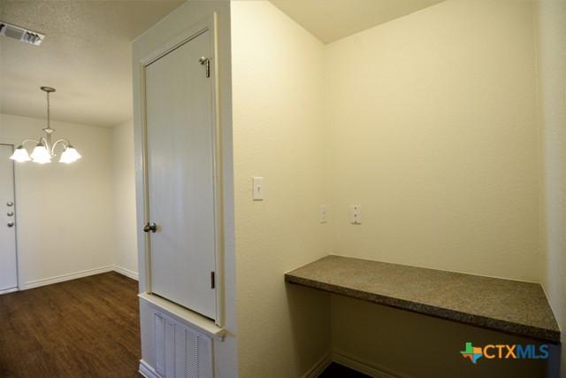 hallway featuring a chandelier and dark hardwood / wood-style flooring