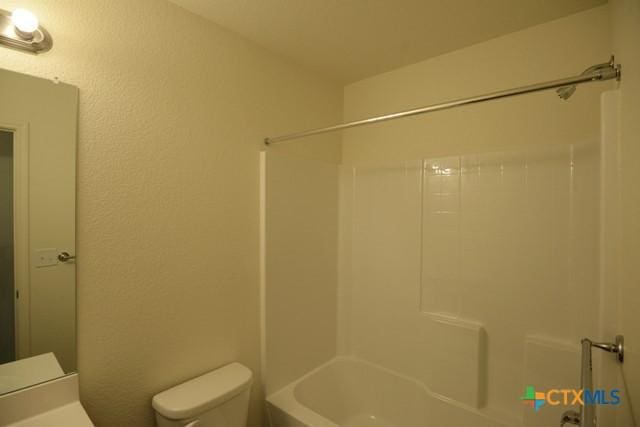 bathroom featuring bathtub / shower combination and toilet