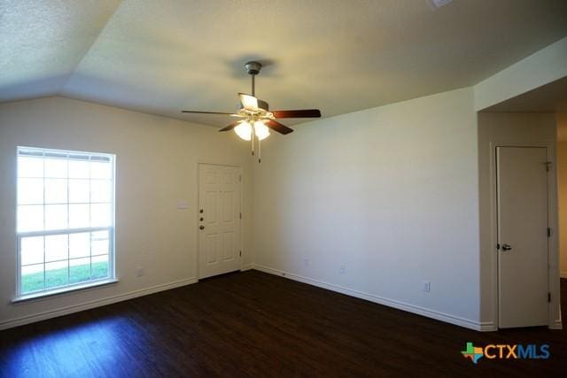 spare room featuring ceiling fan, dark hardwood / wood-style flooring, and lofted ceiling