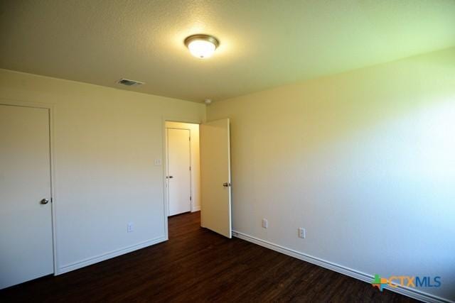 unfurnished bedroom featuring dark wood-type flooring