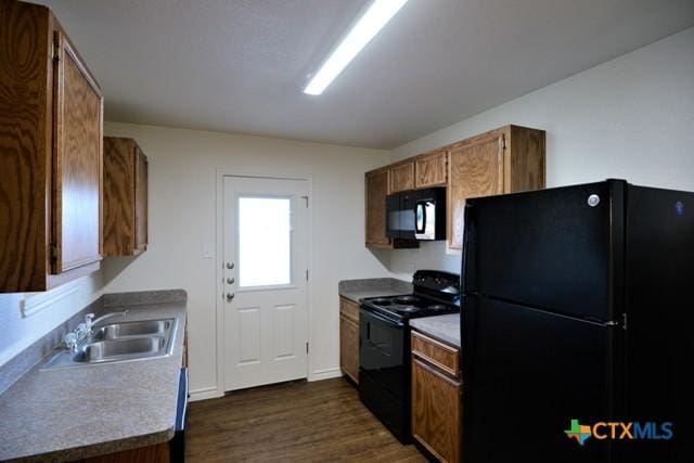 kitchen featuring dark hardwood / wood-style flooring, sink, and black appliances