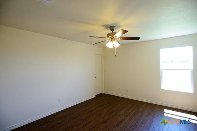 unfurnished room featuring dark hardwood / wood-style floors and ceiling fan