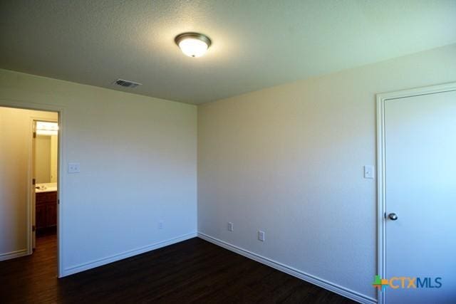 unfurnished room featuring dark wood-type flooring