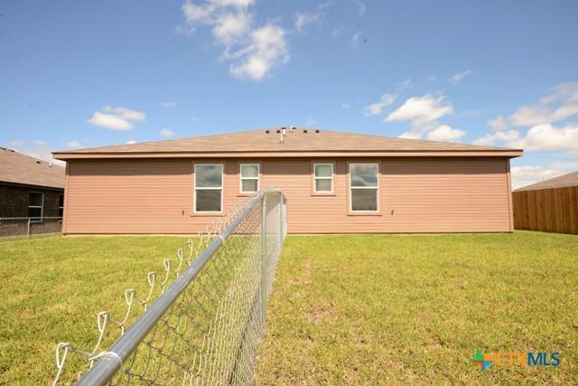 back of property featuring a lawn