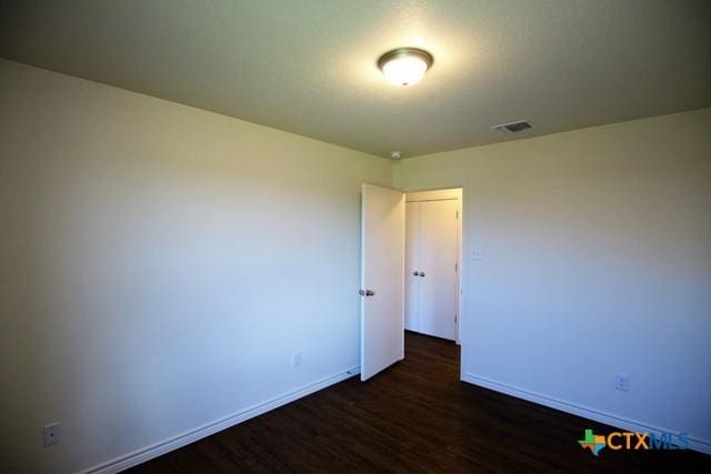 unfurnished room featuring dark hardwood / wood-style floors