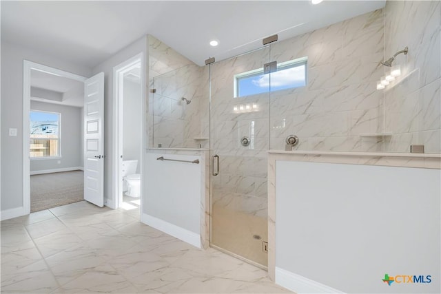 bathroom with toilet, plenty of natural light, marble finish floor, and a marble finish shower