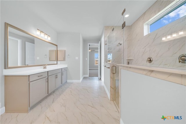 bathroom featuring marble finish floor, a ceiling fan, a marble finish shower, baseboards, and vanity