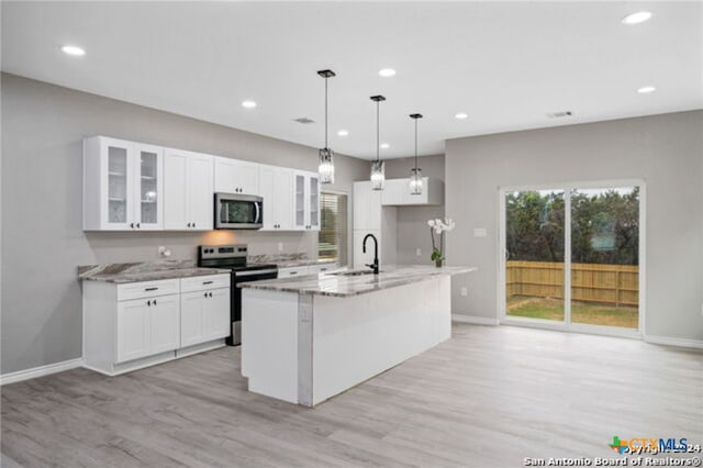 kitchen with sink, light stone counters, white cabinetry, and stainless steel appliances