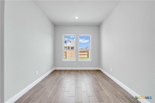 empty room with baseboards and wood finished floors