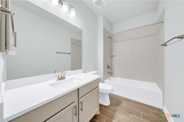 full bathroom featuring visible vents, toilet, wood tiled floor,  shower combination, and vanity