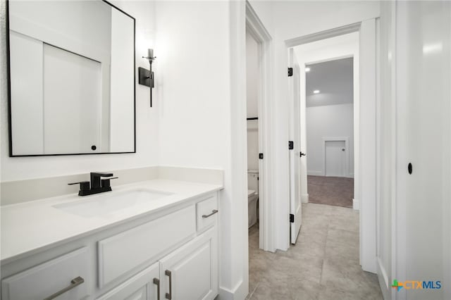 bathroom featuring tile patterned flooring, vanity, and toilet