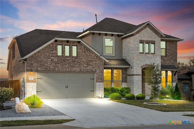 view of front of property with stone siding, driveway, and roof with shingles