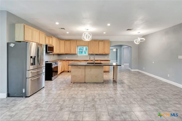 kitchen with pendant lighting, sink, appliances with stainless steel finishes, a center island with sink, and light brown cabinetry