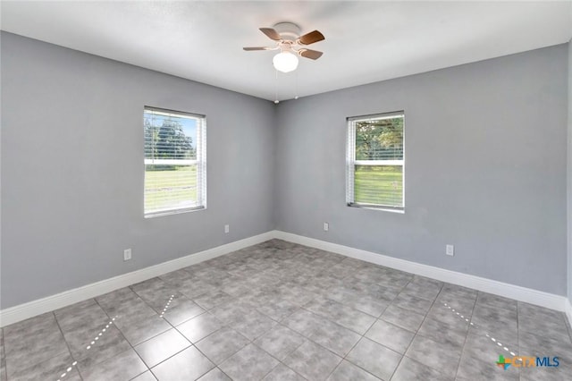 unfurnished room with ceiling fan and a healthy amount of sunlight