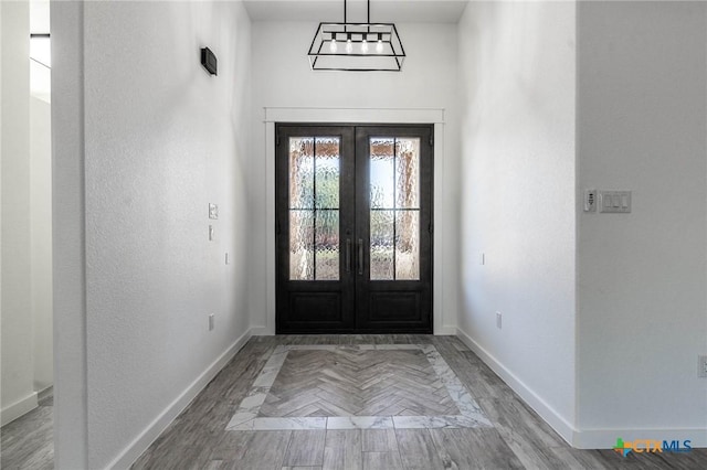 foyer entrance with parquet flooring, french doors, and baseboards