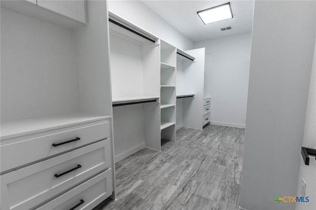 spacious closet featuring visible vents and light wood-type flooring