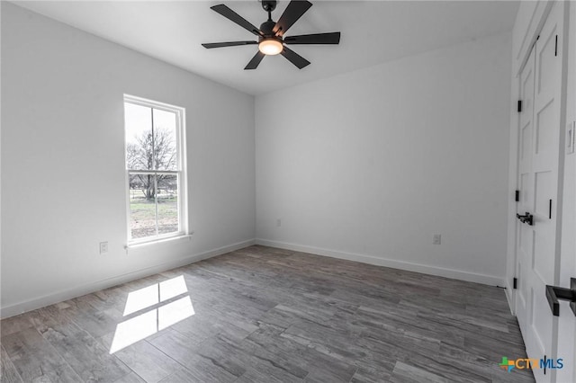 unfurnished bedroom with dark wood-style floors, a ceiling fan, and baseboards