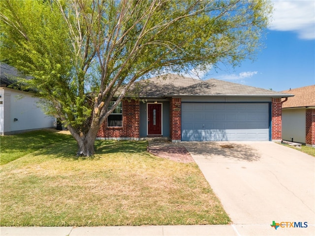 ranch-style home featuring a garage, driveway, brick siding, and a front yard