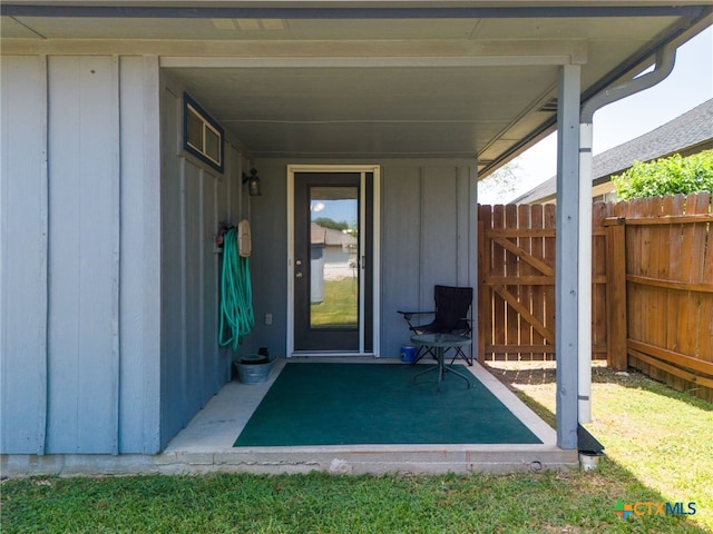 property entrance with fence and board and batten siding