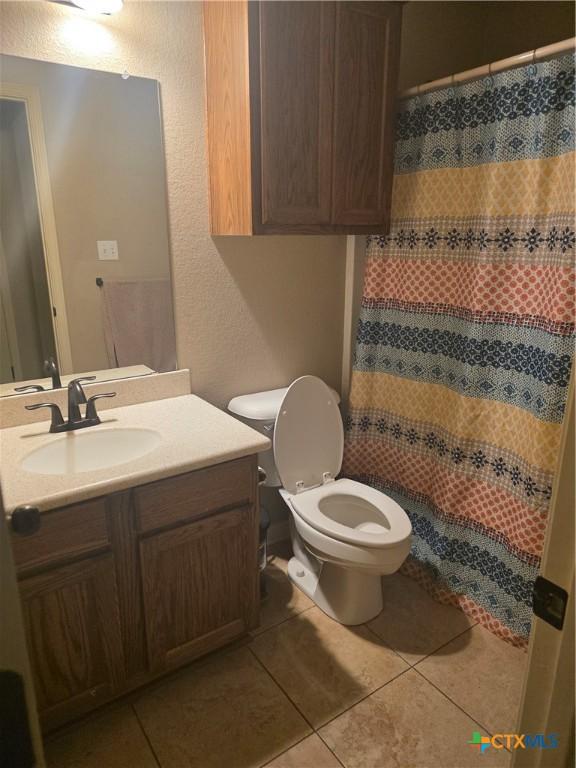 1212 Redstone Dr, Temple, TX 76502 - full bathroom with a textured wall, vanity, tile patterned floors, and a shower with shower curtain