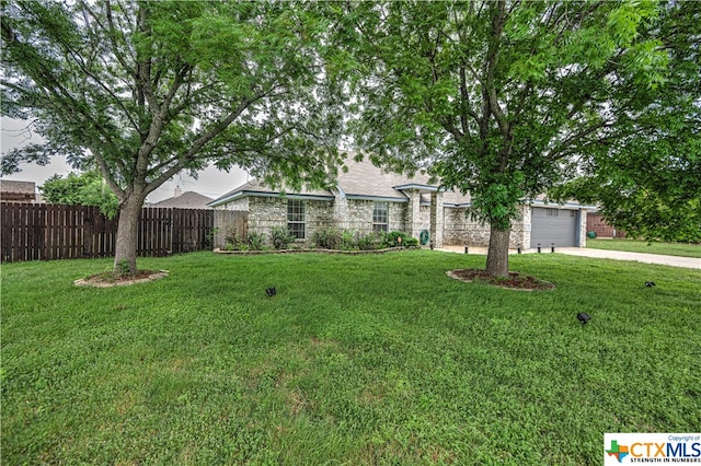 ranch-style home featuring a garage and a front lawn