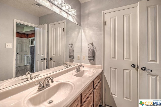 bathroom with vanity and a textured ceiling