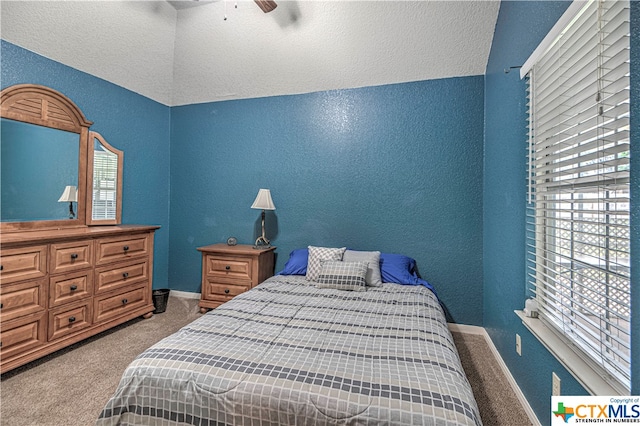 carpeted bedroom featuring ceiling fan, a textured ceiling, and vaulted ceiling