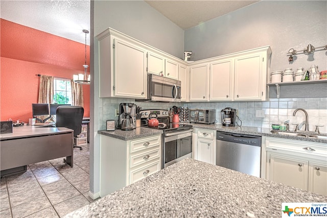 kitchen with stainless steel appliances, backsplash, light tile patterned floors, hanging light fixtures, and sink