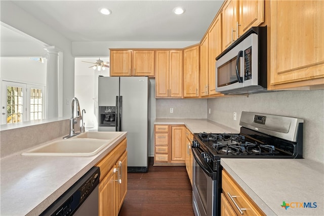 kitchen featuring stainless steel appliances, sink, ceiling fan, dark hardwood / wood-style floors, and decorative columns