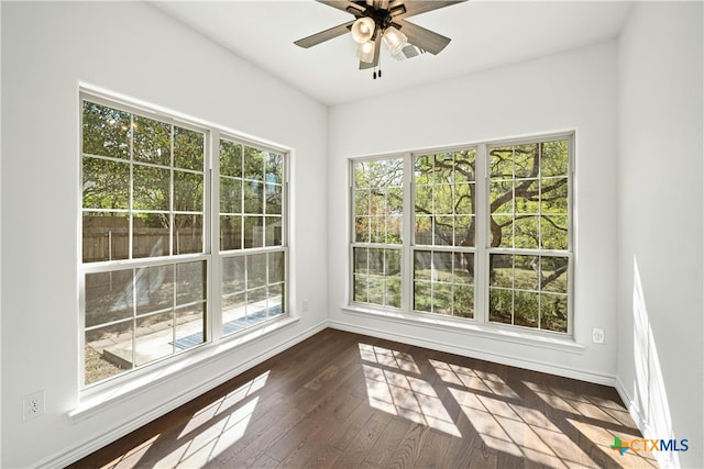 unfurnished sunroom featuring ceiling fan and a healthy amount of sunlight