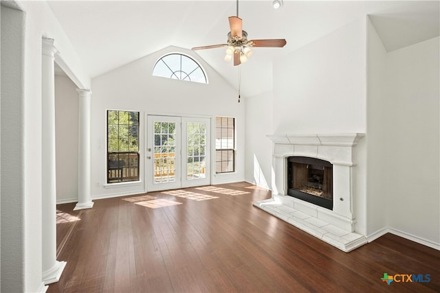 unfurnished living room with a fireplace, ornate columns, dark hardwood / wood-style floors, vaulted ceiling, and ceiling fan