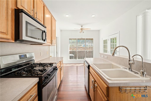 kitchen featuring dark hardwood / wood-style flooring, ceiling fan, sink, and appliances with stainless steel finishes