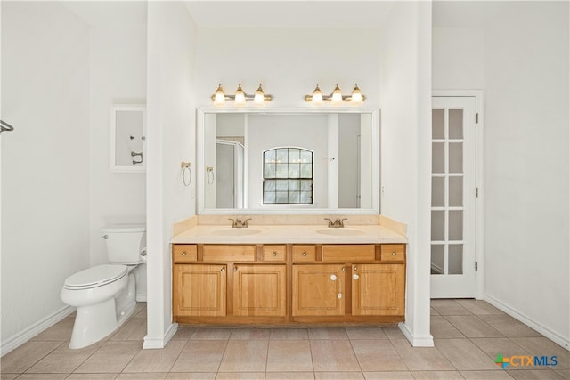 bathroom with vanity, walk in shower, tile patterned flooring, and toilet