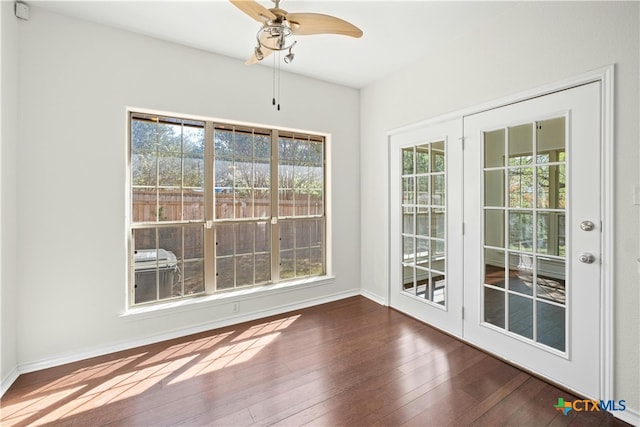 unfurnished dining area featuring a wealth of natural light, ceiling fan, and dark hardwood / wood-style flooring