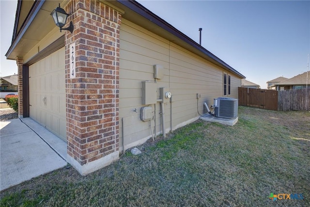 view of home's exterior featuring cooling unit, driveway, fence, brick siding, and a garage
