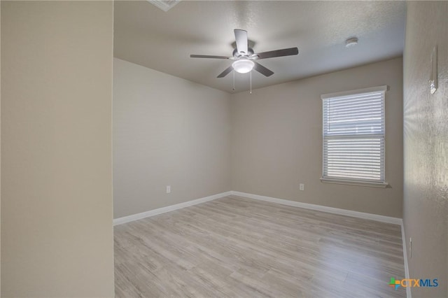 spare room with ceiling fan, a textured ceiling, and light hardwood / wood-style flooring