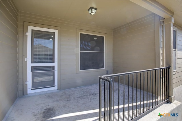 doorway to property featuring concrete block siding and a patio area