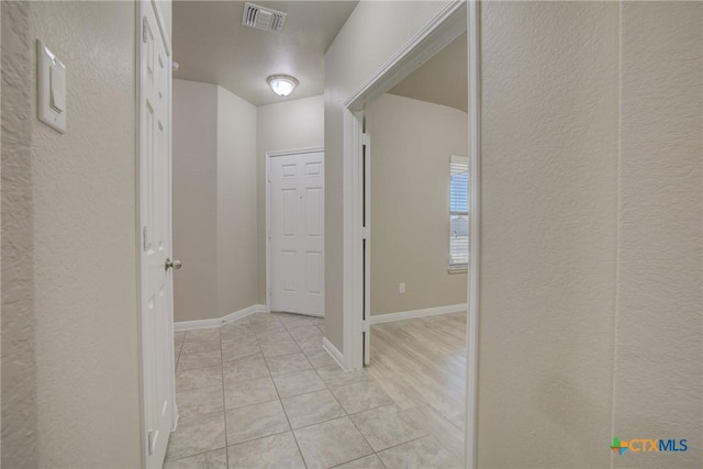 hall with light tile patterned floors