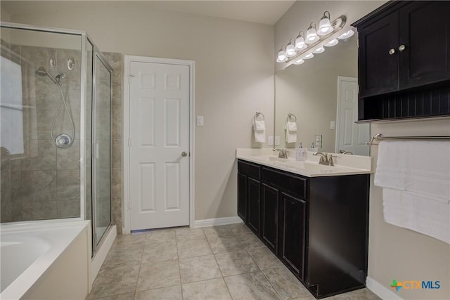 bathroom featuring tile patterned flooring, double vanity, a sink, a bath, and a stall shower