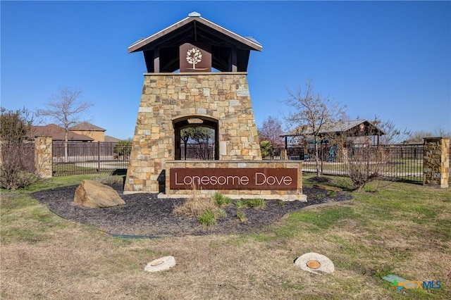 community / neighborhood sign featuring fence