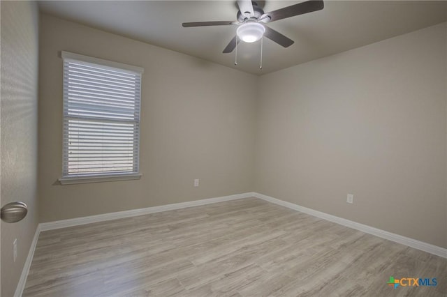 spare room featuring baseboards, light wood-style floors, and ceiling fan