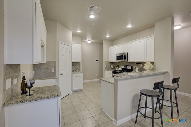 kitchen featuring light stone countertops, white cabinets, and appliances with stainless steel finishes